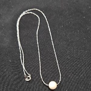 Delicate silver chain necklace with a single pearl pendant. 16"
